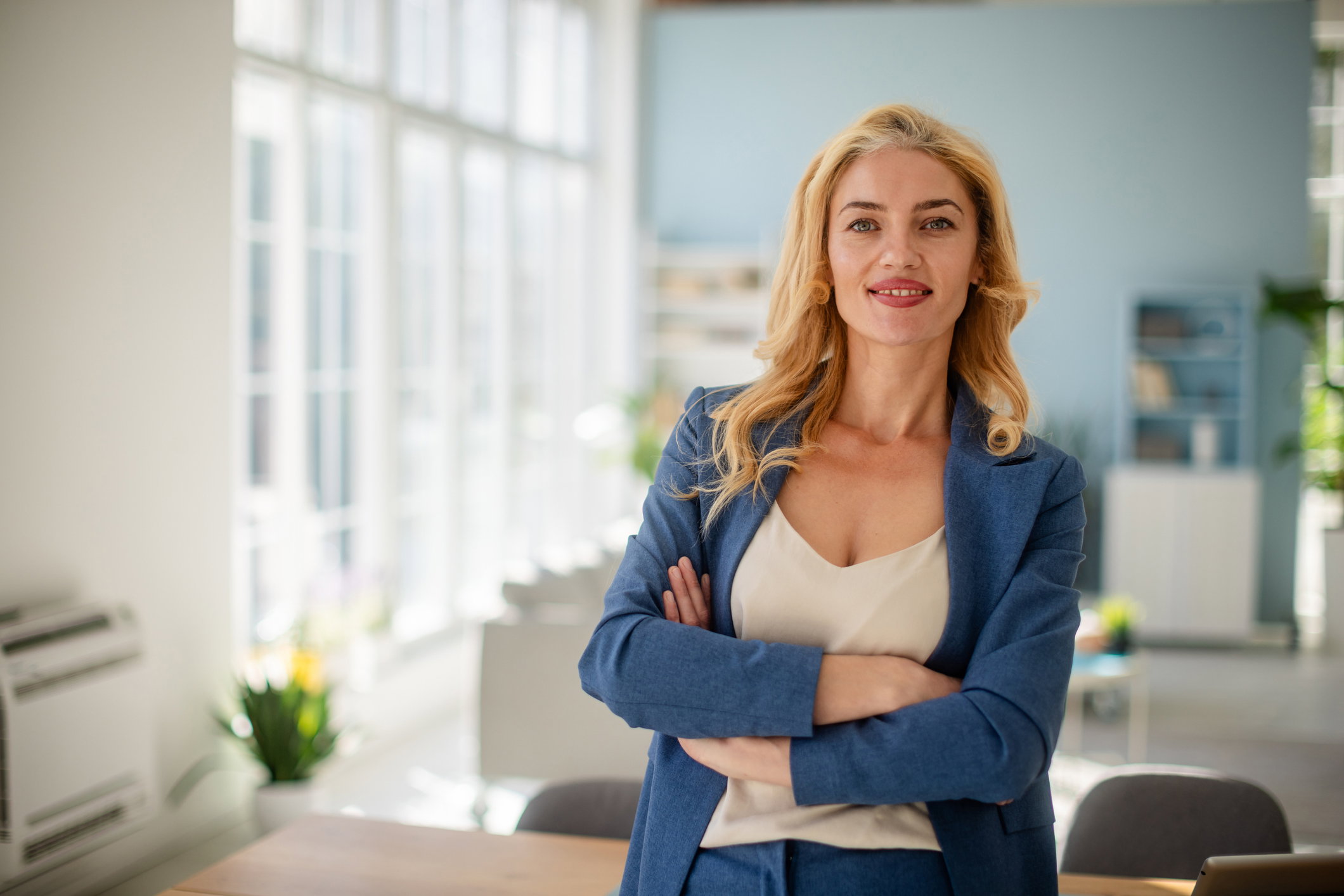 Professional woman confidently poses in office ambiance.