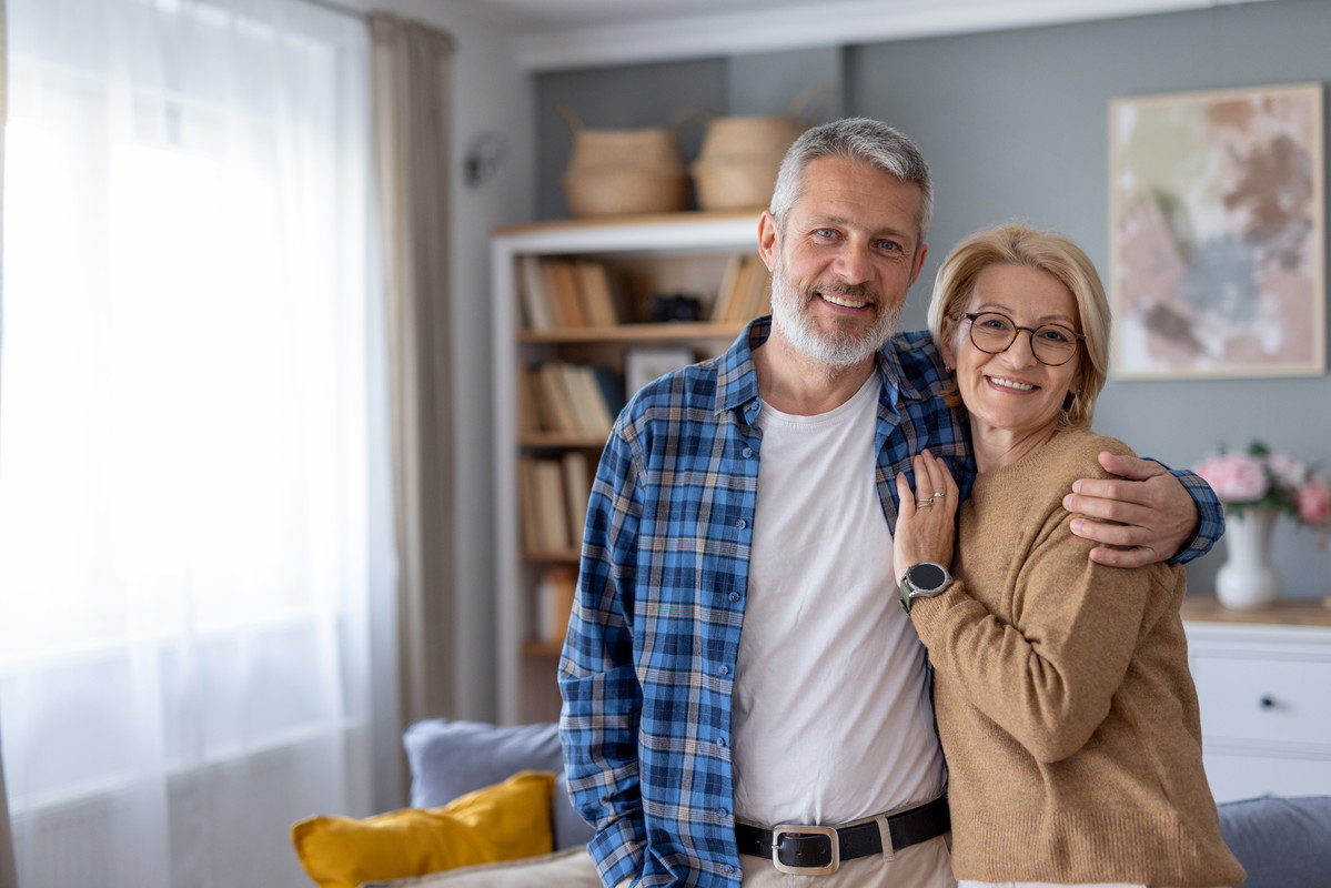 Smiling couple poses happily in their stylish living area