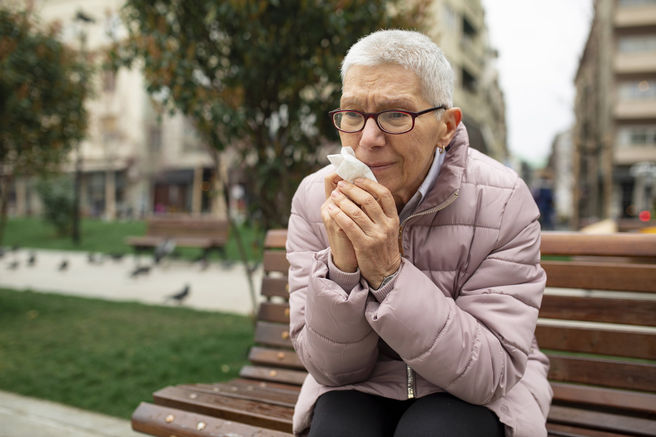 Elderly pensioner sitting on a park bench