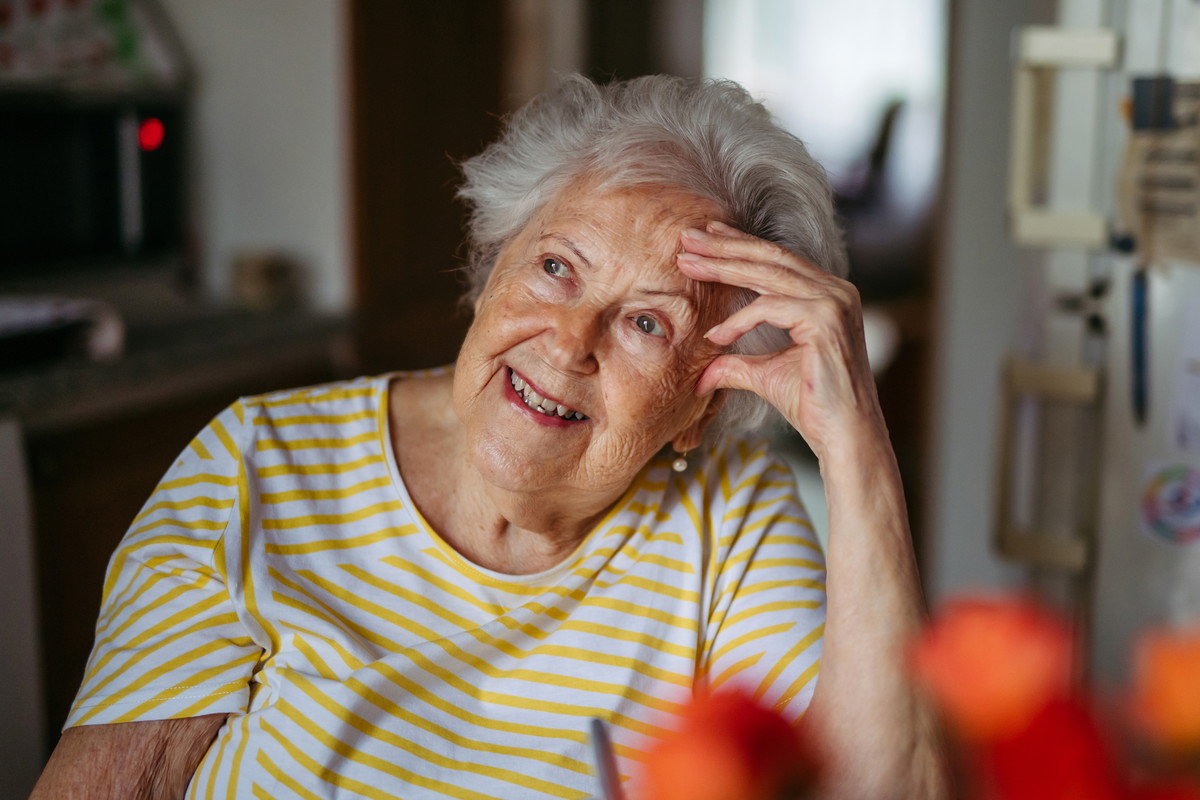 Portrait of worried senior woman crying in kitchen.