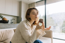 Sweet Escape: Young Woman Savoring Chocolate on a Cozy Sofa