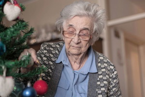 Smutna kobieta stroi choinkę