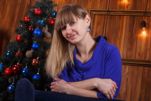 Uśmiechnięta kobieta na tle choinki