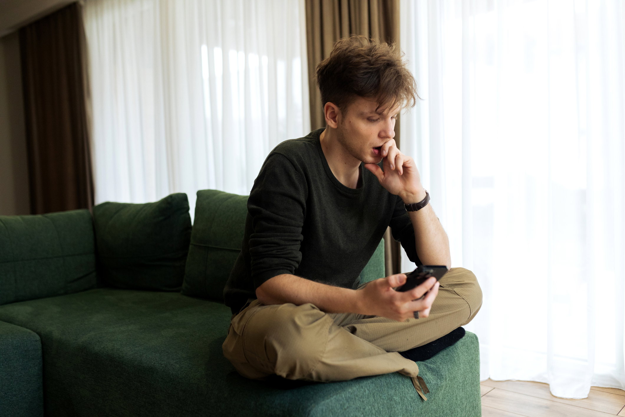 Young male using his phone at home
