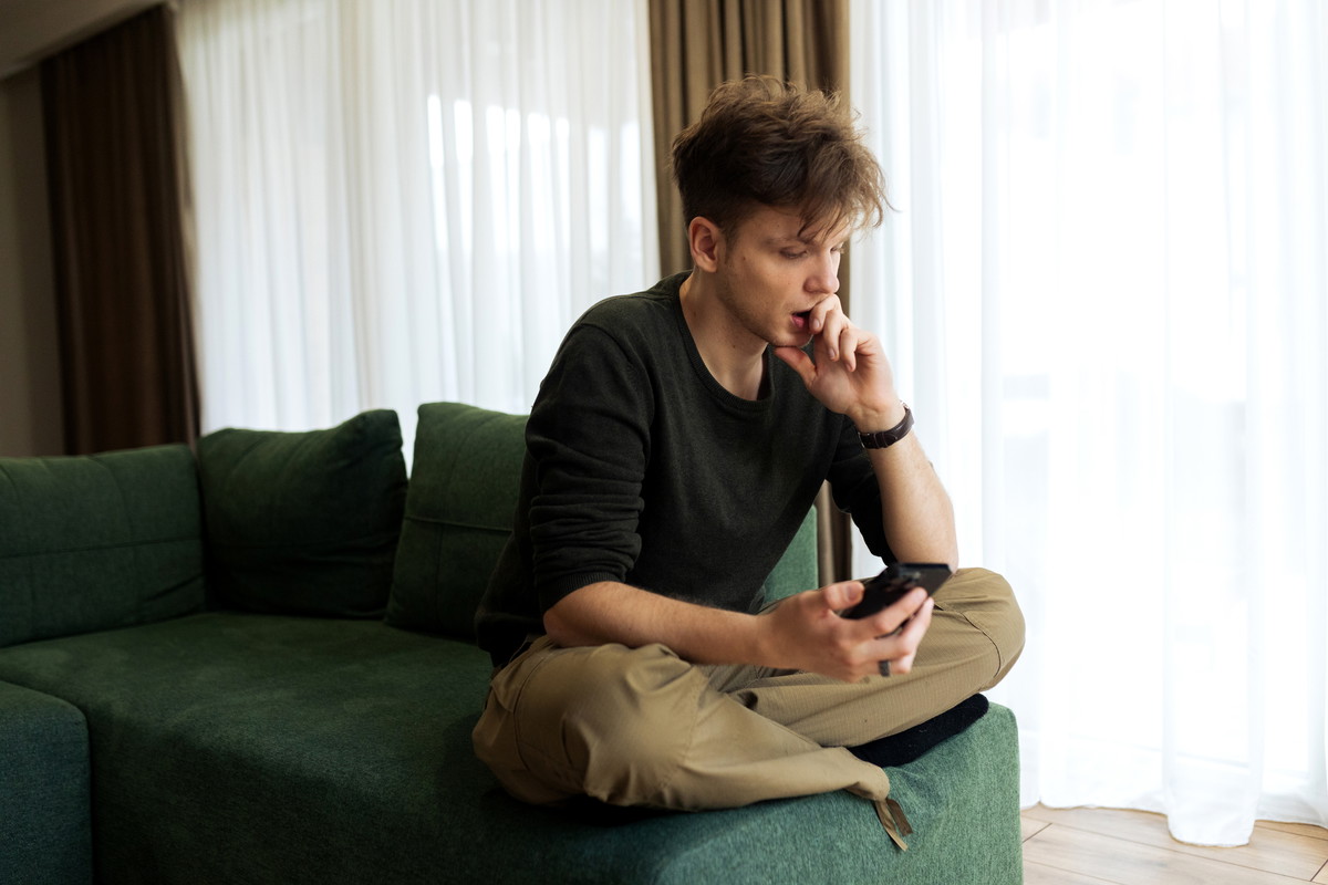 Young male using his phone at home