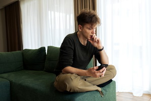 Young male using his phone at home