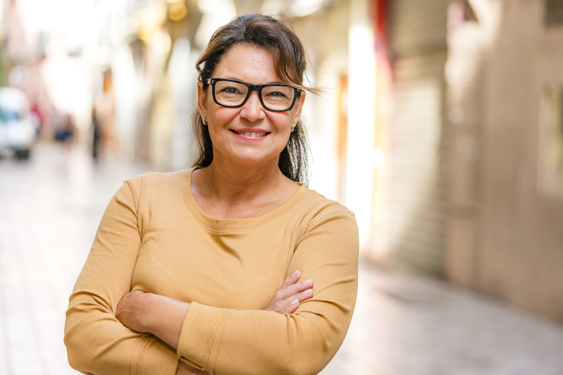 Portrait of an Hispanic smiling mature woman arms crossed outdoors