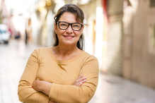 Portrait of an Hispanic smiling mature woman arms crossed outdoors