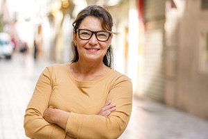 Portrait of an Hispanic smiling mature woman arms crossed outdoors