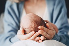 Newborn in mother's hands. Baby care. Childbirth and motherhood
