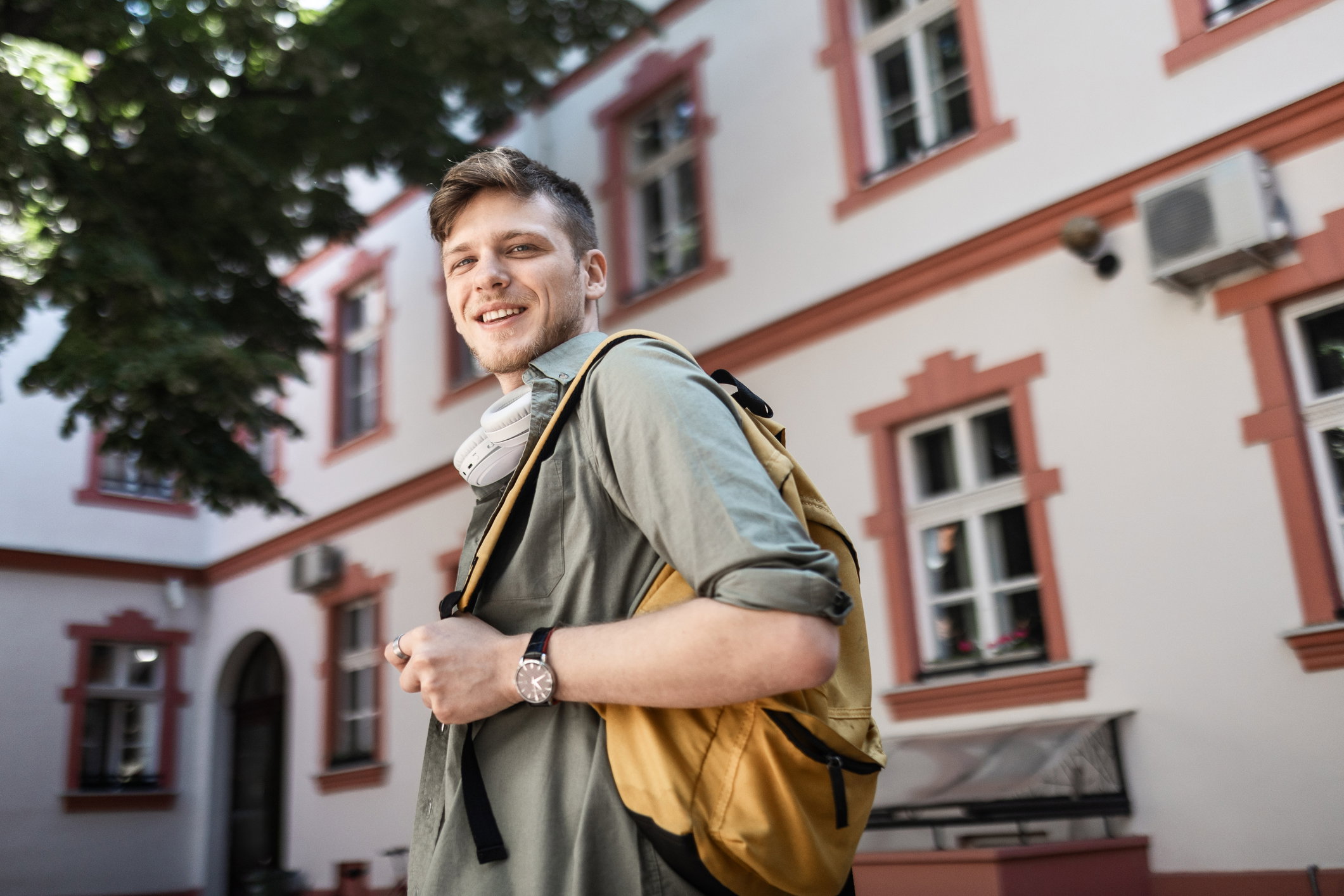 Young Man Holding Books and Wearing Headphones