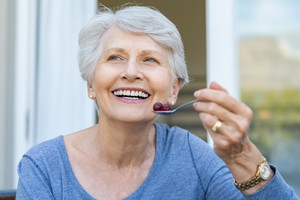 uśmiechnięta seniorka w ogrodzie