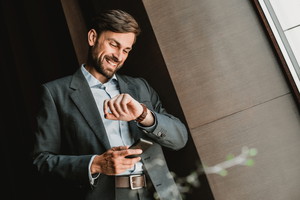 Zadowolony mężczyzna patrzący na zegarek