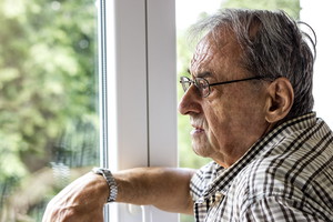 senior patrzący przez okno