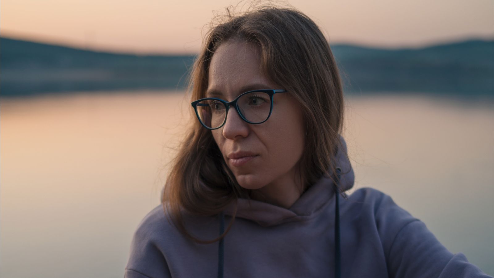 Zamyślona kobieta nad jeziorem