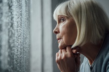 zamyślona seniorka w oknie