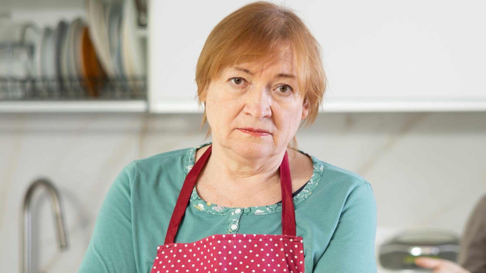 Poważna kobieta w średnim wieku w kuchni