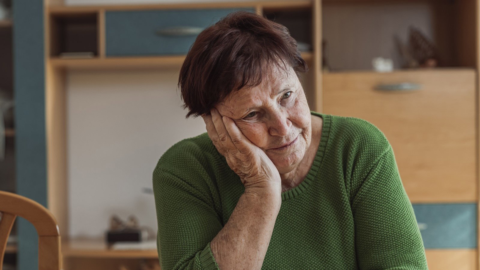 zasmucona seniorka w salonie