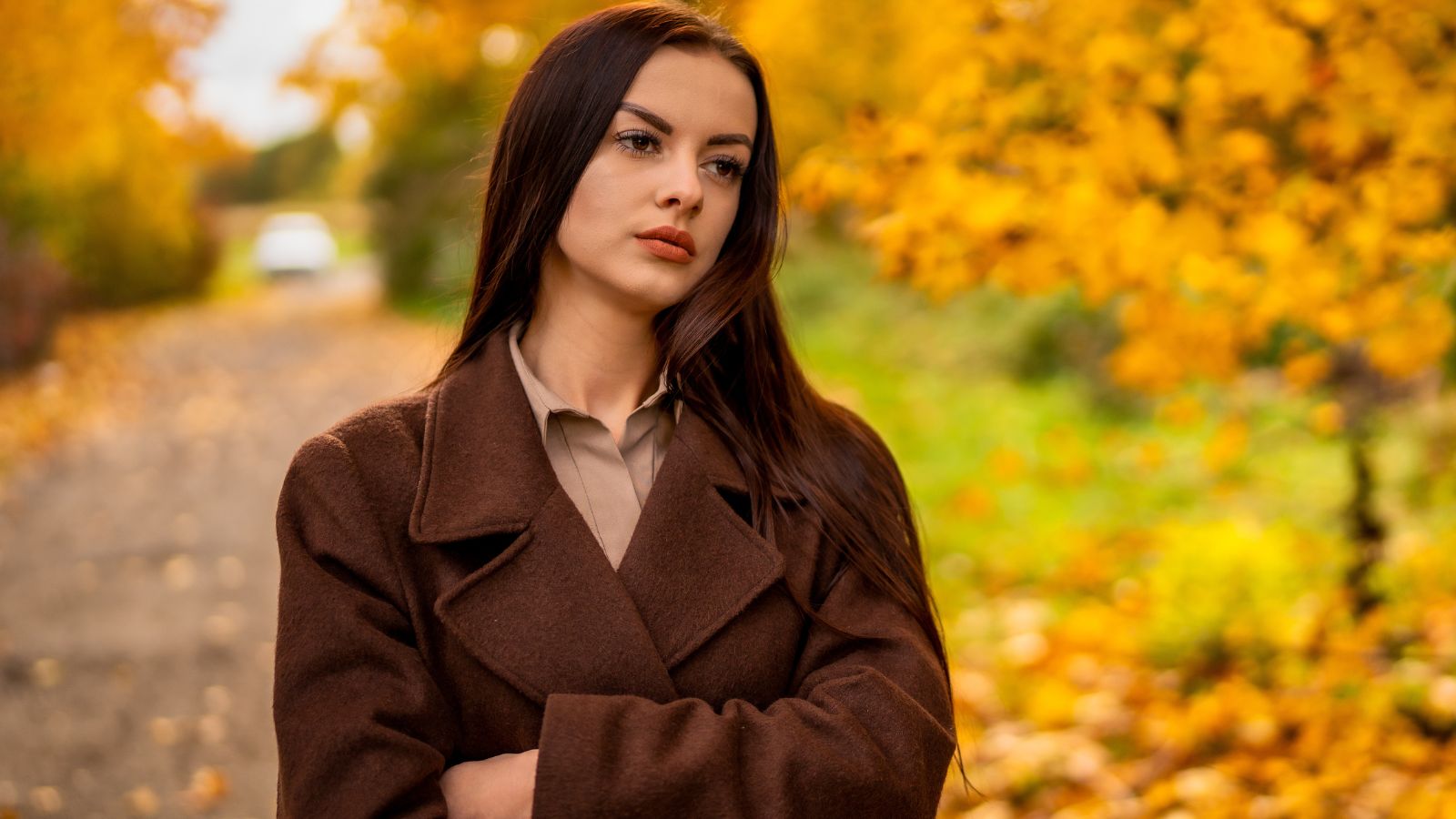 Niezadowolona kobieta na tle jesiennej uliczki