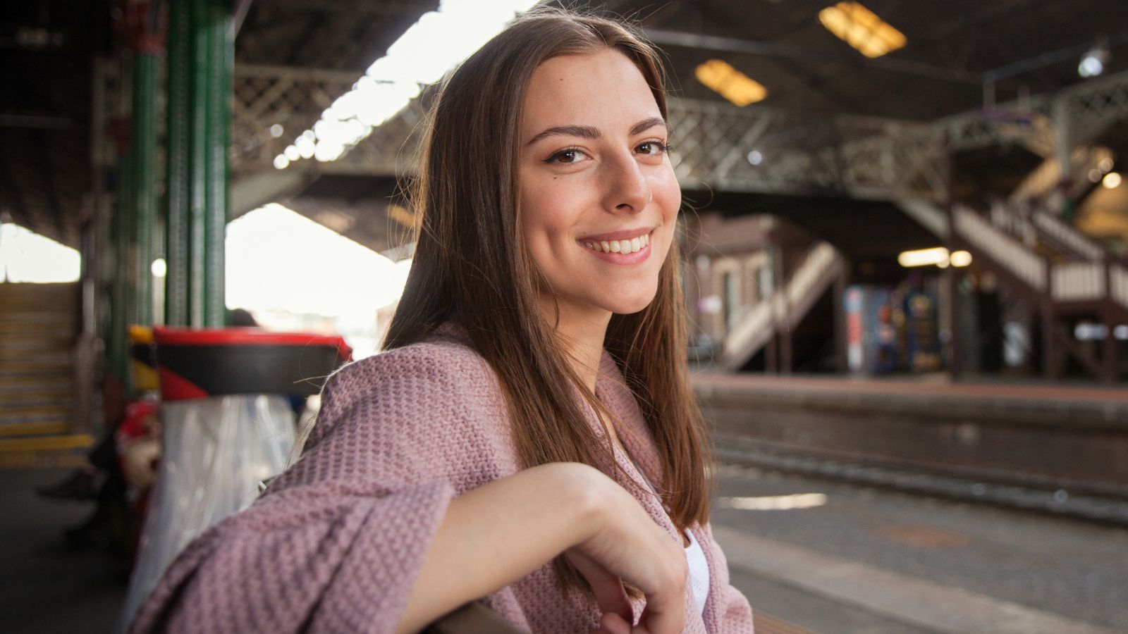 Uśmiechnięta kobieta na stacji kolejowej