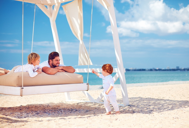 happy family enjoying summer vacation at the sea beach