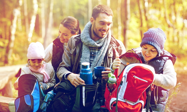 happy family with backpacks and thermos at camp
