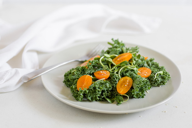 Fresh cale salad with orange tomatoes, sesame seeds and sunflowe