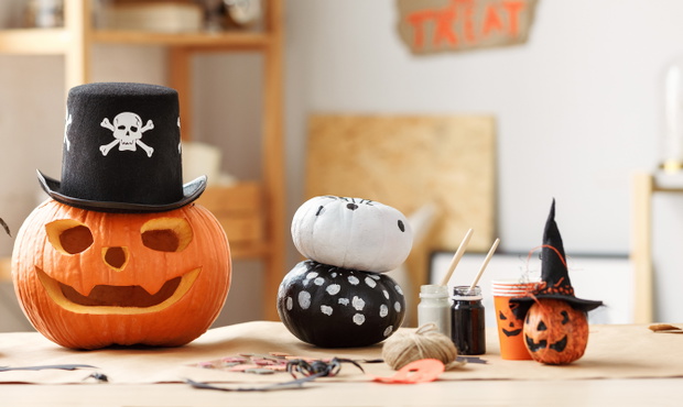 Classic carven spooky jack-o-lantern in pirate hat standing on wooden table