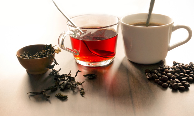 Coffee and tea with coffee bean and tea leaves on wooden floor.