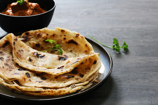 Homemade layered Paratha / Parotta or Indian flat bread with Paneer curry