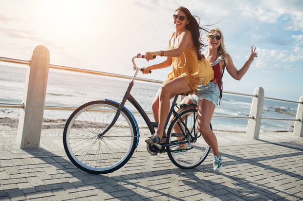 Stylish young female friends on a bicycle