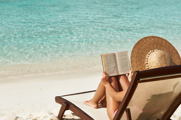 Young woman reading a book at beach