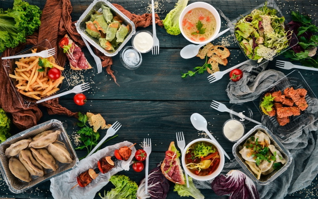 Food in lunch boxes. Delivery of food. Ukrainian cuisine. On a wooden background. Top view. Copy space.