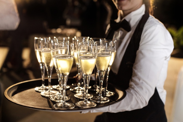cameriere con un vassoio pieno di calici con aperitivo di prosecco
