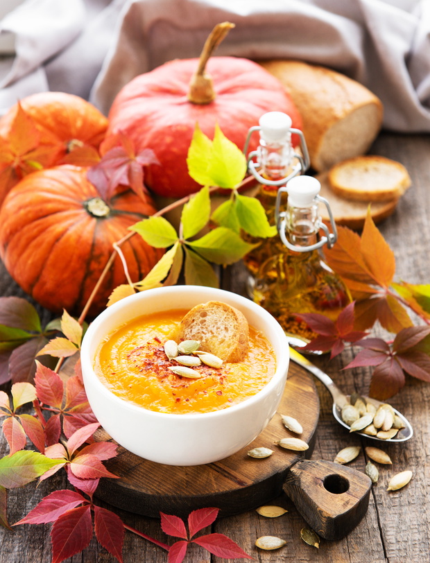 Bowl of pumpkin soup on rustic wooden background