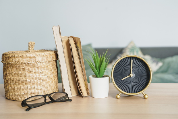 Alarm clock and office stationery objects close up on wooden table