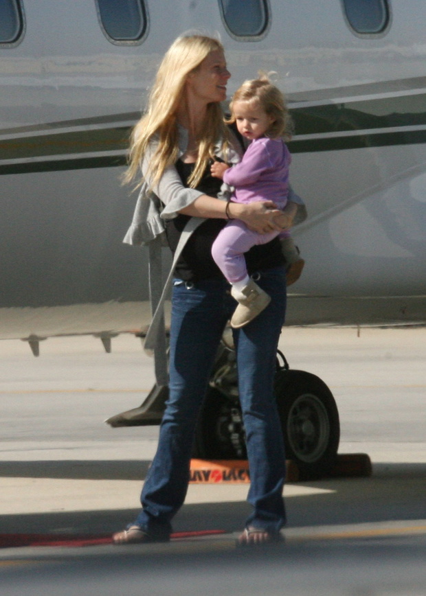 Gwyneth Paltrow readies Apple for a flight on a private jet. 1/1
