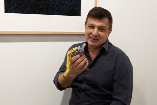David Datuna shows the remains of the artwork 'Comedian' by the artist Maurizio Cattelan at Perrotin stand in Art Basel in Miami Beach