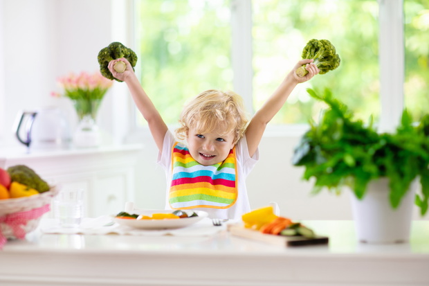 Baby eating vegetables. Solid food for infant.