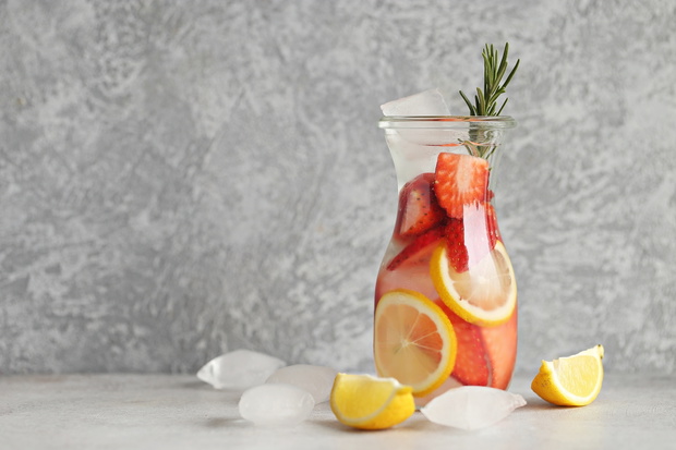 Berry infused water, coctail, lemonade or tea. Summer iced cold drinks with strawberry, blueberry, raspberry, lemon and herbs Selective focus