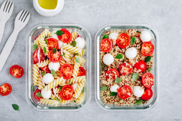 Meal prep containers with pasta salad or quinoa, tomatoes, mozza