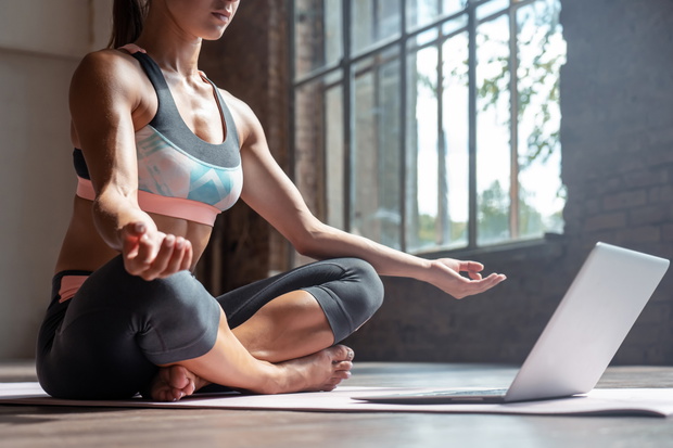 Young slim girl meditate online in hatha yoga easy pose healthy lifestyle.