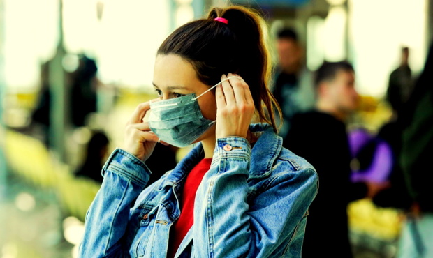 Woman wearing protective mask in airport, Coronavirus contagion