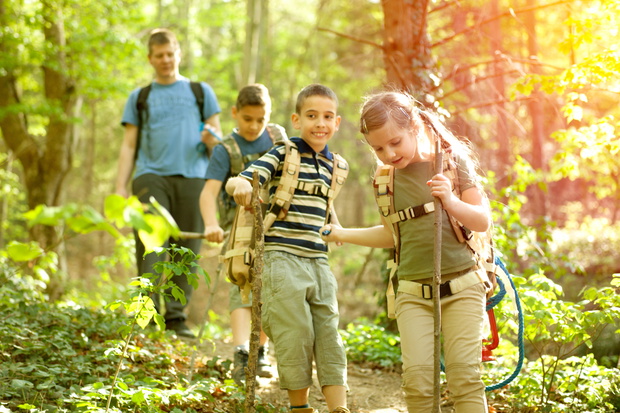 Children scouts and father explore the beautiful forest