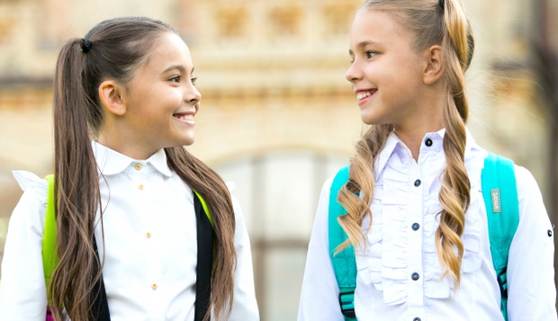 Soulmate friends. Cute schoolgirls with long ponytails looking charming. Ending of school year. Cheerful smart schoolgirls. Happy schoolgirls outdoors. Small schoolgirls wear school uniform
