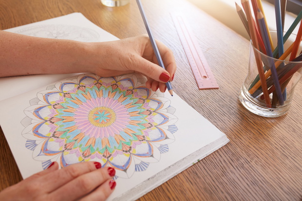 Woman hands drawing in adult colouring book