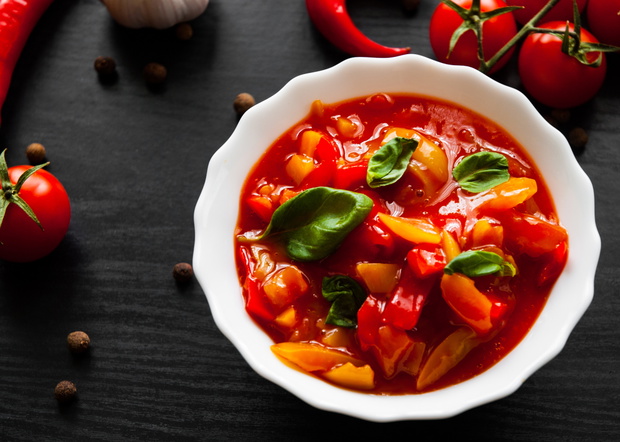 Delicious letcho with fresh vegetables in bowl on dark wooden background