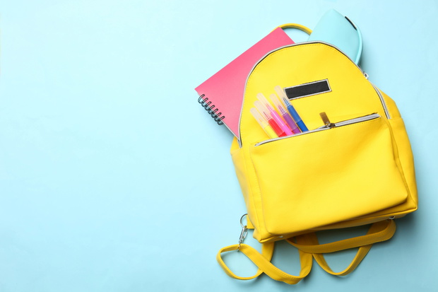 yellow backpack with different school supplies