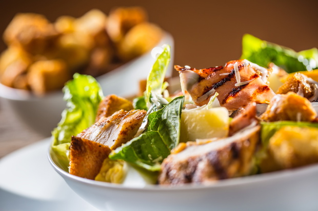 Delicious salad caesar with grilled chicken breast croutons eggs bacon parmesan cheese and lettuce with dressing