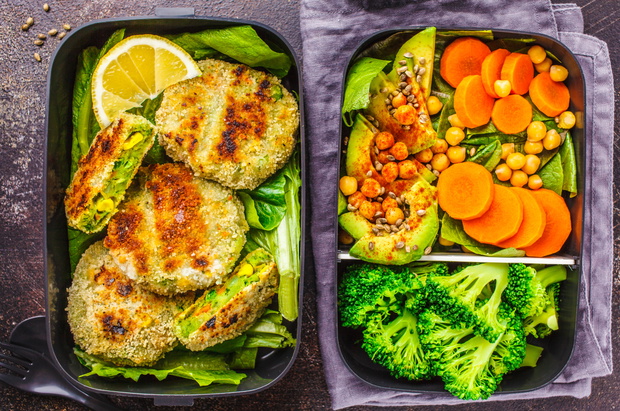 Healthy meal prep containers with green burgers, broccoli, chickpeas and salad.